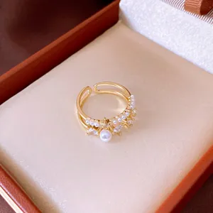 Close-up detail of a vintage double-layer gold open ring featuring elegant pearls and zircons