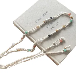 Collana etnica in corda di cotone intrecciata con perle di resina colorate e lacci