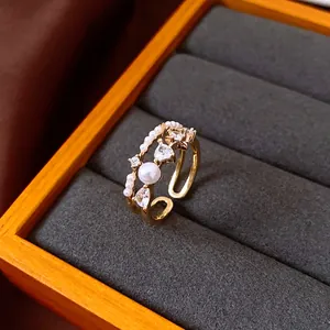 Detail view of retro double-layer gold open ring with pearls and heart-shaped zircons.