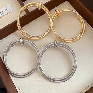 Macro view showing the shimmering textured surface of gold and silver hoop earrings