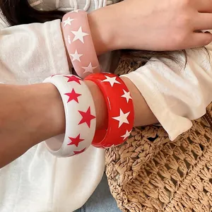 Bracelets joncs en résine avec étoiles colorées en rose, blanc et rouge portés ensemble