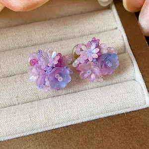 Gros plan détaillé de boucles d'oreilles en perles de verre violettes et bleues