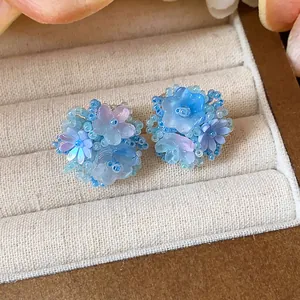 Vue détaillée de boucles d'oreilles fleurs en perles de verre bleues et roses faites main.