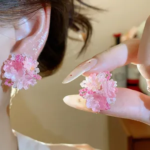 Gros plan de boucles d'oreilles fleuries en perles de verre rose aux détails doux
