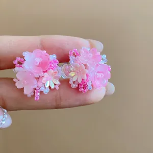 Gros plan de boucles d'oreilles fleurs roses en perles faites à la main avec détails