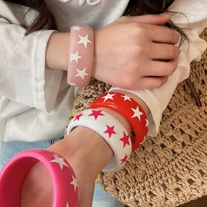 Gros plan sur des joncs colorés en résine avec étoiles pour un look de mode tendance