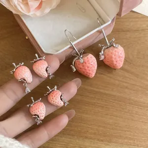 Detailansicht der rosa Erdbeer-Ohrringe mit silbernen Akzenten und funkelnden Kristallen