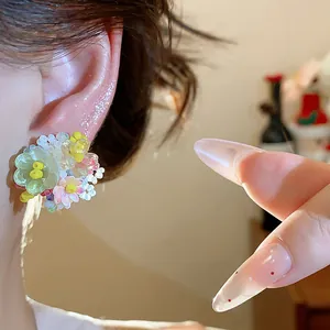 Détail de boucles d'oreilles fleurs en perles de verre dopamine portées