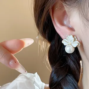 Elegant close-up view of French style enamel flower earrings with a white pearl