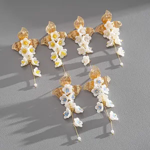 Eleganti orecchini a fiore con nappe dorate e petali in vetro per un look estivo.