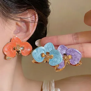 Retro-Ohrringe mit bunten Emaille-Blumen und goldenen Details.