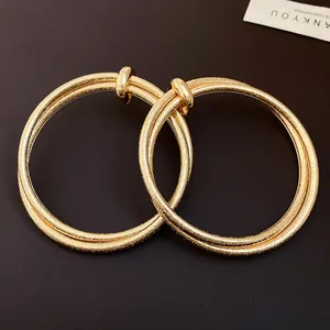 Detailed macro view of gold textured interlocking hoop earrings for women