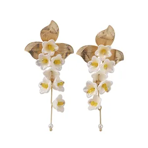 Eleganti orecchini pendenti a fiore con petali di vetro bianco e foglie in metallo dorato