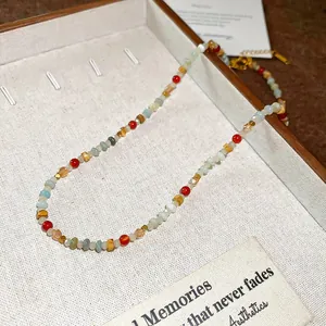Dettaglio della collana bohémien in cristallo retrò con perline geometriche colorate.