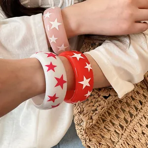 Gros plan détaillé de bracelets en résine colorés avec des motifs d'étoiles sur un bras