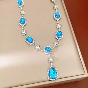 Elegant silver necklace with blue teardrop and oval crystal stones, vintage court style.