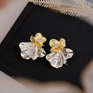 Macro detail of elegant two-tone flower earrings featuring center crystal accents
