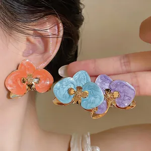 Detailansicht der Retro-Orchideen-Ohrringe mit bunten Emaille-Blütenblättern und Gold