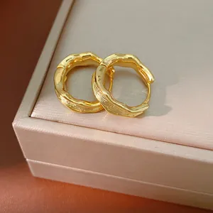 Close-up of elegant 18k gold plated crumpled textured hoop earrings on a jewelry box