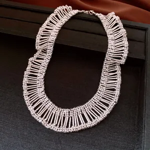 Macro view of elegant pleated silver fringe necklace showing intricate metallic beadwork.