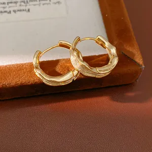 Close-up detail of 18k gold plated wrinkled hoop earrings with elegant textured surface