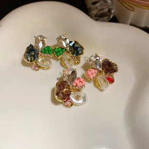 Close-up of elegant flower stud earrings with sparkling rhinestones and colorful beads