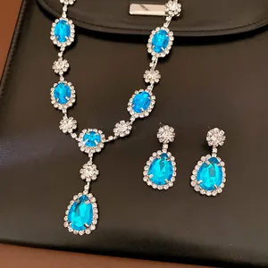Close-up detail of luxurious blue teardrop crystal necklace and earring jewelry set