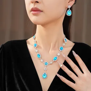Elegant vintage blue teardrop crystal necklace and earring set shown on model detail view