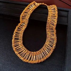 Exquisite gold-tone tiered necklace with pleated bar details on a jewelry display tray