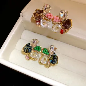 Detailed close-up of elegant floral stud earrings featuring rhinestones and colorful pearls