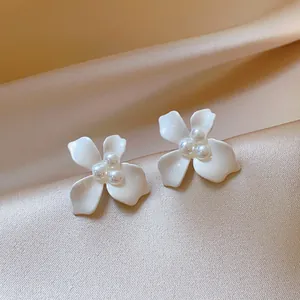 Close-up view of elegant white flower stud earrings with delicate pearl accents