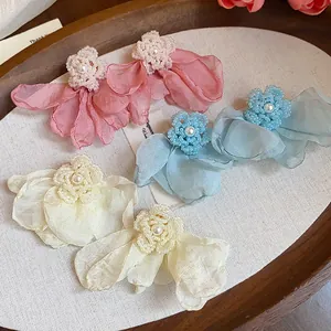 Detailed view of handmade chiffon flower pearl earrings in pink, blue, and cream colors
