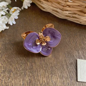 Detaillierte Nahaufnahme lila Emaille Orchideen-Ohrstecker mit goldenen Akzenten
