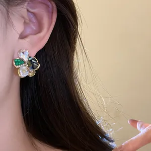 Elegant floral stud earring with sparkling diamond and pearl detailing worn by a model