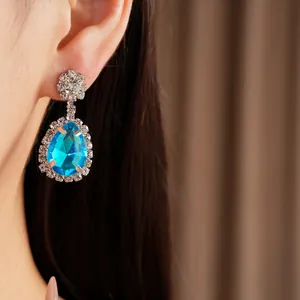 Close-up of elegant blue water drop earrings with rhinestones on model's ear