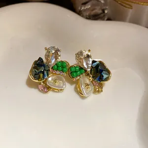 Detailed macro view of elegant floral stud earrings with colorful crystals and pearls