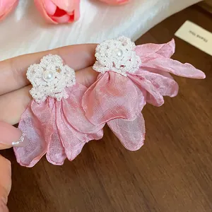 Close-up of pink chiffon flower pearl earrings with delicate seed bead details.
