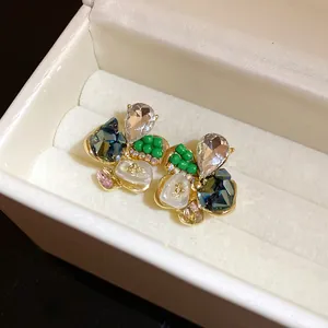 Detailed macro view of elegant floral stud earrings featuring colorful crystals and beads