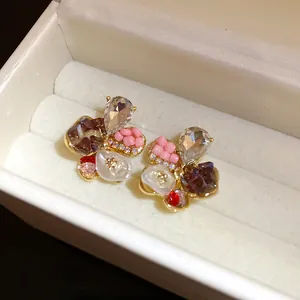 Detailed macro view of elegant floral stud earrings featuring multi-colored crystals and pearls