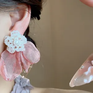 Detailed view of elegant silver needle stud earrings with chiffon flowers and pearls.
