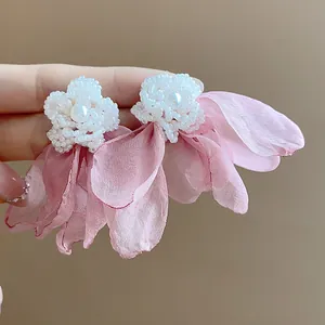 Detail shot of elegant pink chiffon flower earrings with white beaded pearl center