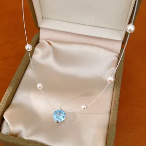 Detailed view of a light blue zircon flower necklace with elegant pearls in a gift box