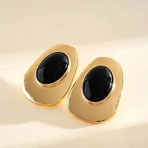 Close-up of vintage gold-tone oval stud earrings with black resin inlay