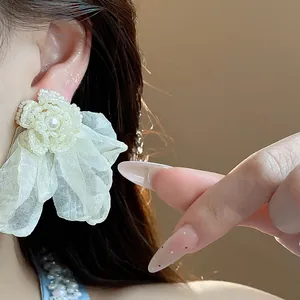 Detailed close-up of elegant chiffon flower pearl earring showing exquisite texture