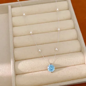 Detail of a light blue zircon flower pendant with pearls in a velvet jewelry tray