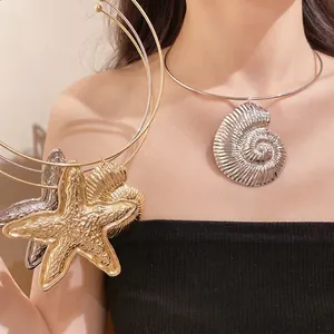 Statement bohemian starfish and nautilus shell pendant necklace in metallic gold and silver