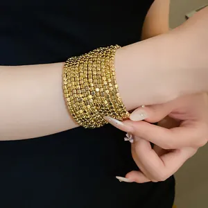 Detailed view of a gold multi-layered square beaded wrap bracelet on a woman's wrist.