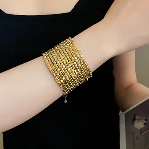Detailed view of a vintage gold multi-layer square bead winding bracelet on wrist