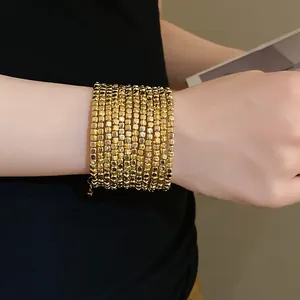 Detailed view of a retro multi-layer wrap bracelet with polished gold square beads
