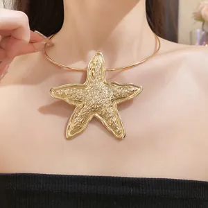 Elegant close-up of a bohemian style oversized gold starfish pendant choker necklace on a model